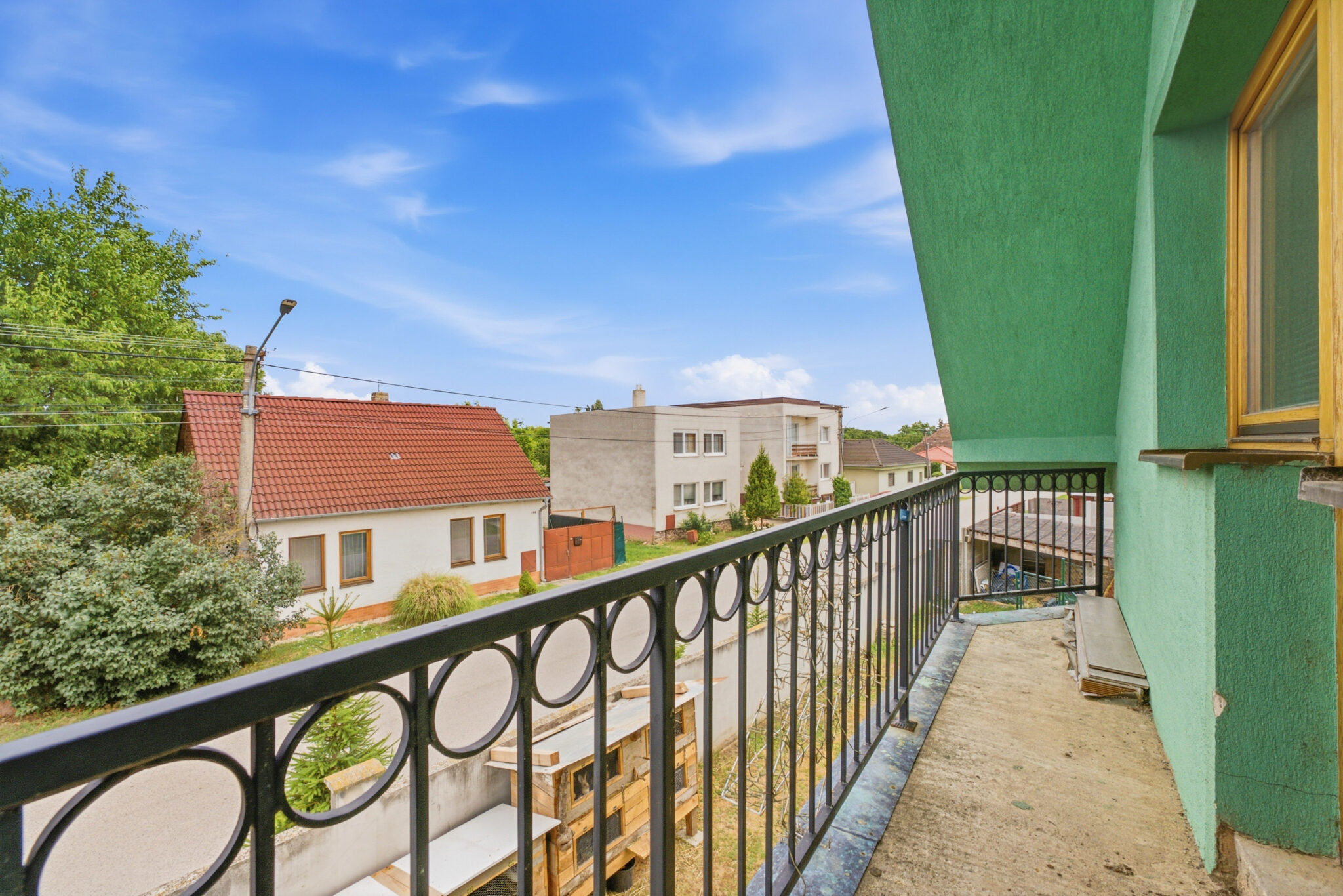 Výhľad z balkóna 5-izbového rodinného domu na okolitú zástavbu a ulicu